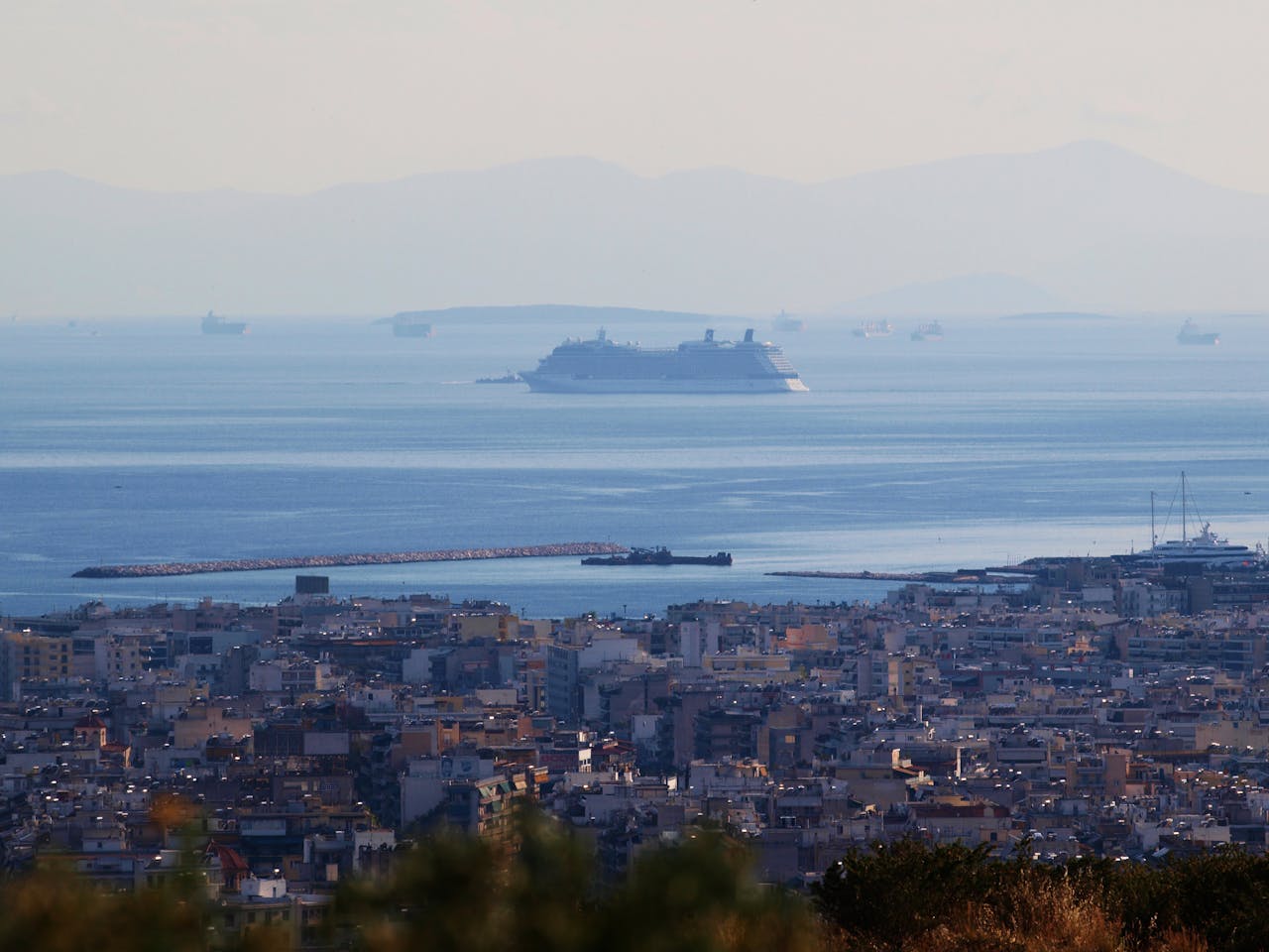 Panoramic view of Athens coastline with cruise ships in the Mediterranean Sea, highlighting urban and maritime scenery.